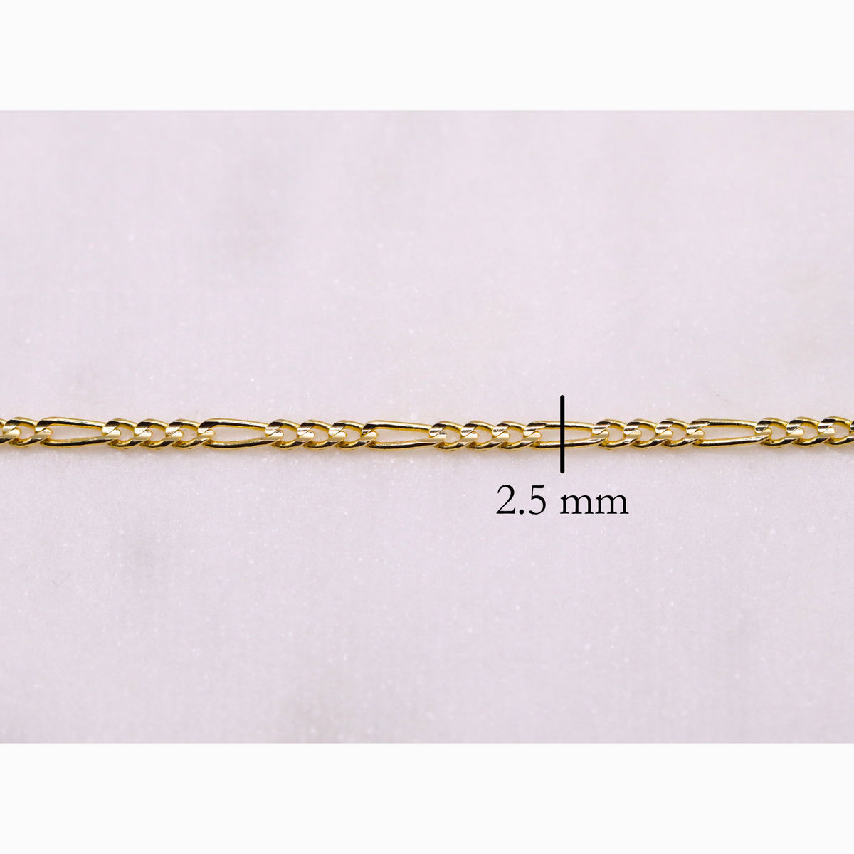 Figaro schakelketting 2,5 mm 14k goud, close-up van de schakels op witte achtergrond